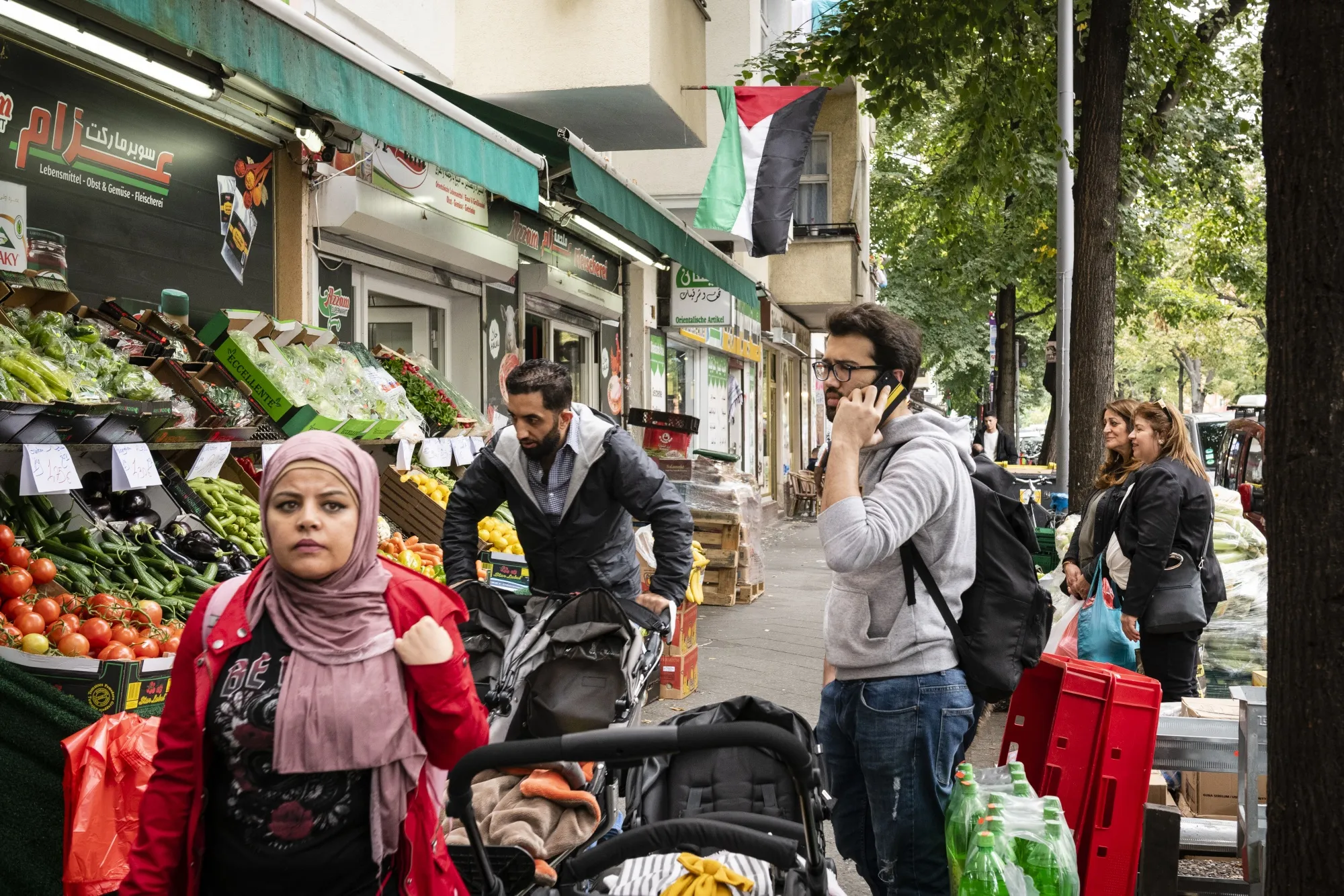 Pedestrians pass a food store on Sonnenallee in Berlin, Germany.