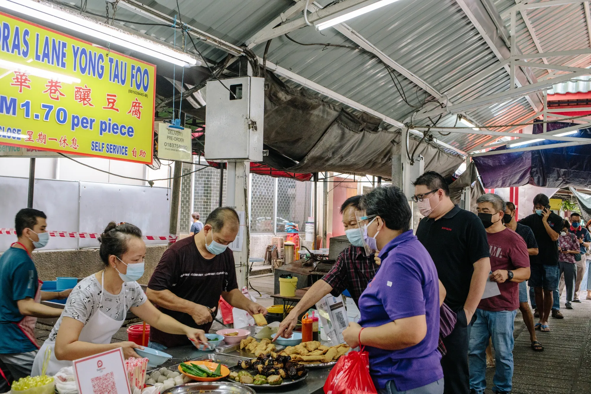Customers in line for food at a market in Kuala Lumpur.