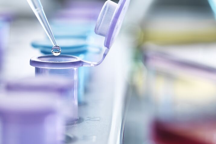 Pipetting droplets of liquid into eppendorf tubes, side view