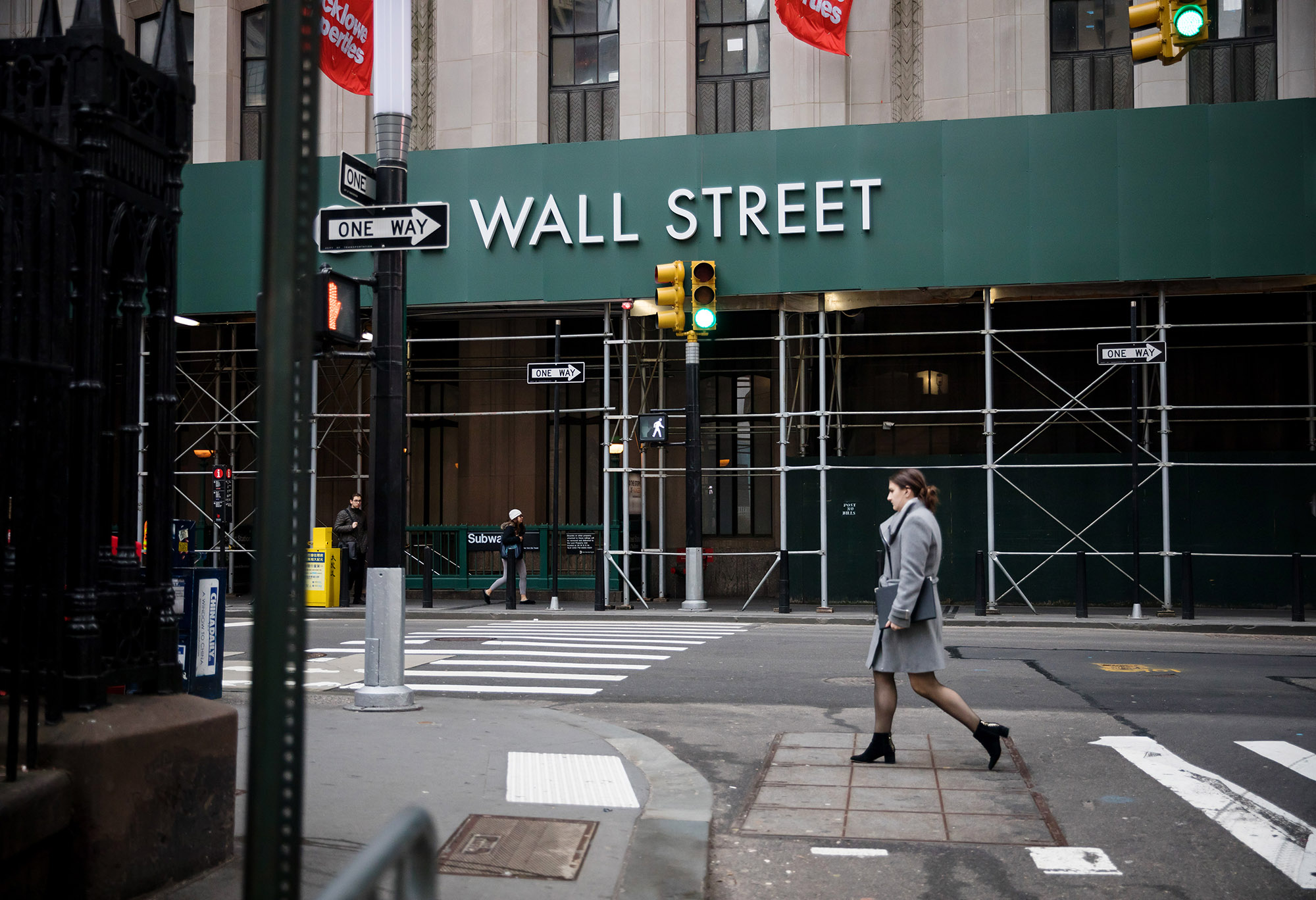 A pedestrian walks up Broadway near the New York Stock Exchange.