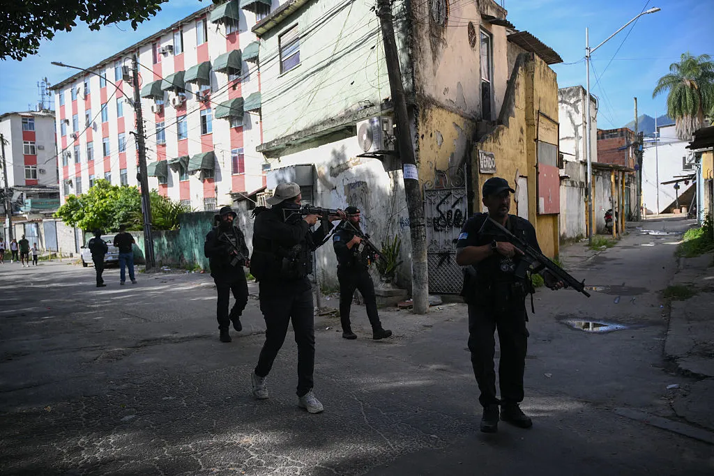 Civil Police officers patrol a street in the Cidade de Deus neighborhood during a police operation in Rio de Janeiro.&nbsp;