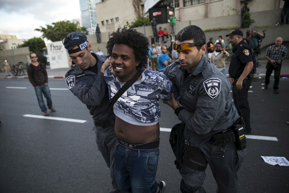 An Israeli Jew of Ethiopian ethnicity is detained by police during a demonstration against what protesters say is institutional racism and brutality in the police force.