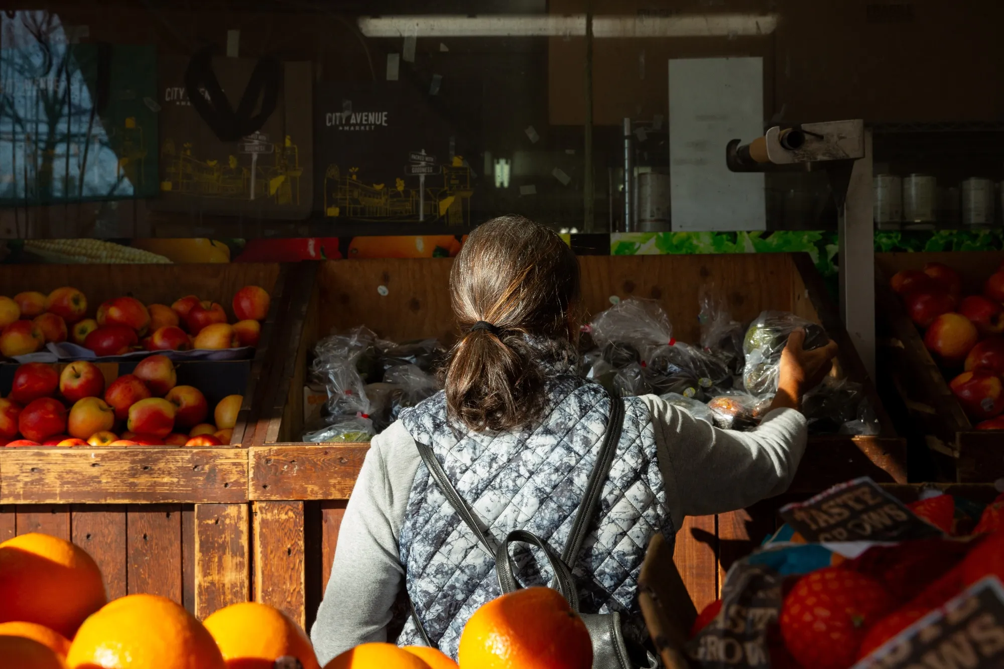A shopper selects produce at a grocery store in Vancouver.