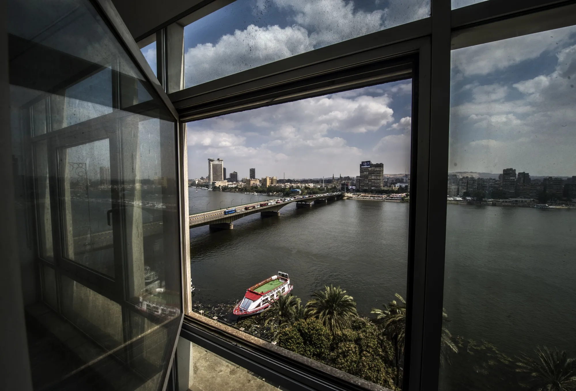 A picture taken through the window of a building shows the Nile river and Cairo's skyline. (Photographer: Khaled Desouki/AFP via Getty Images)