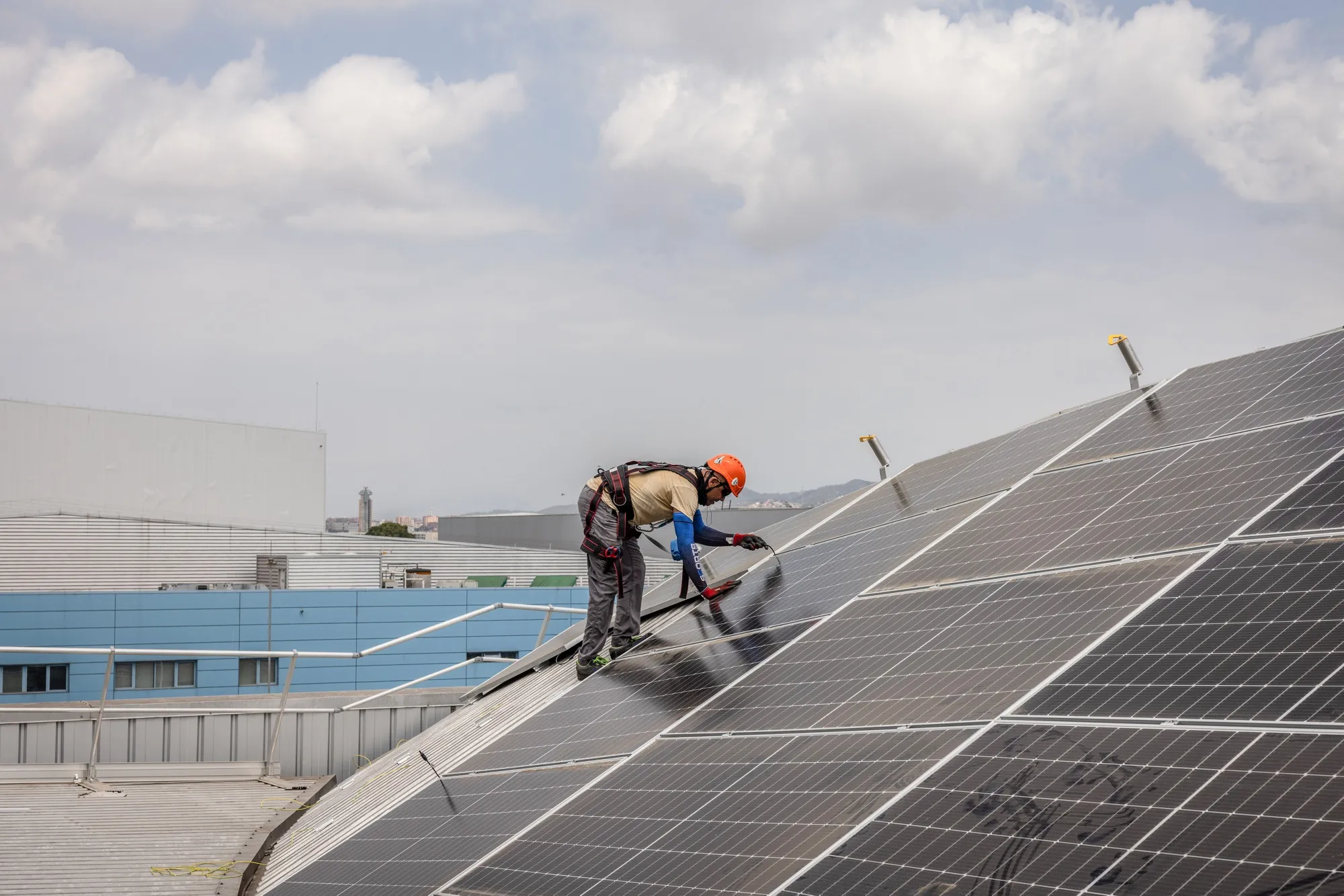 A worker installs solar panels on the roof of a Barcelona Metro workshop building, the Generalitat of Catalonia's largest solar power project, in the Zona Franca industrial area of Barcelona, Spain, on Friday, July 21, 2023.