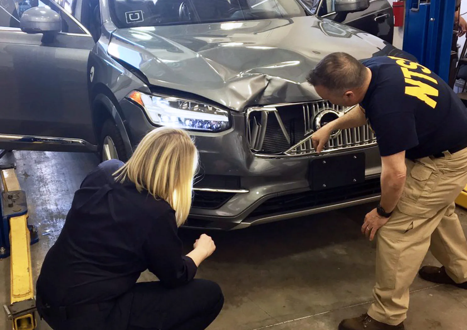 Investigators examine the driverless Uber SUV that fatally struck a woman in Tempe.