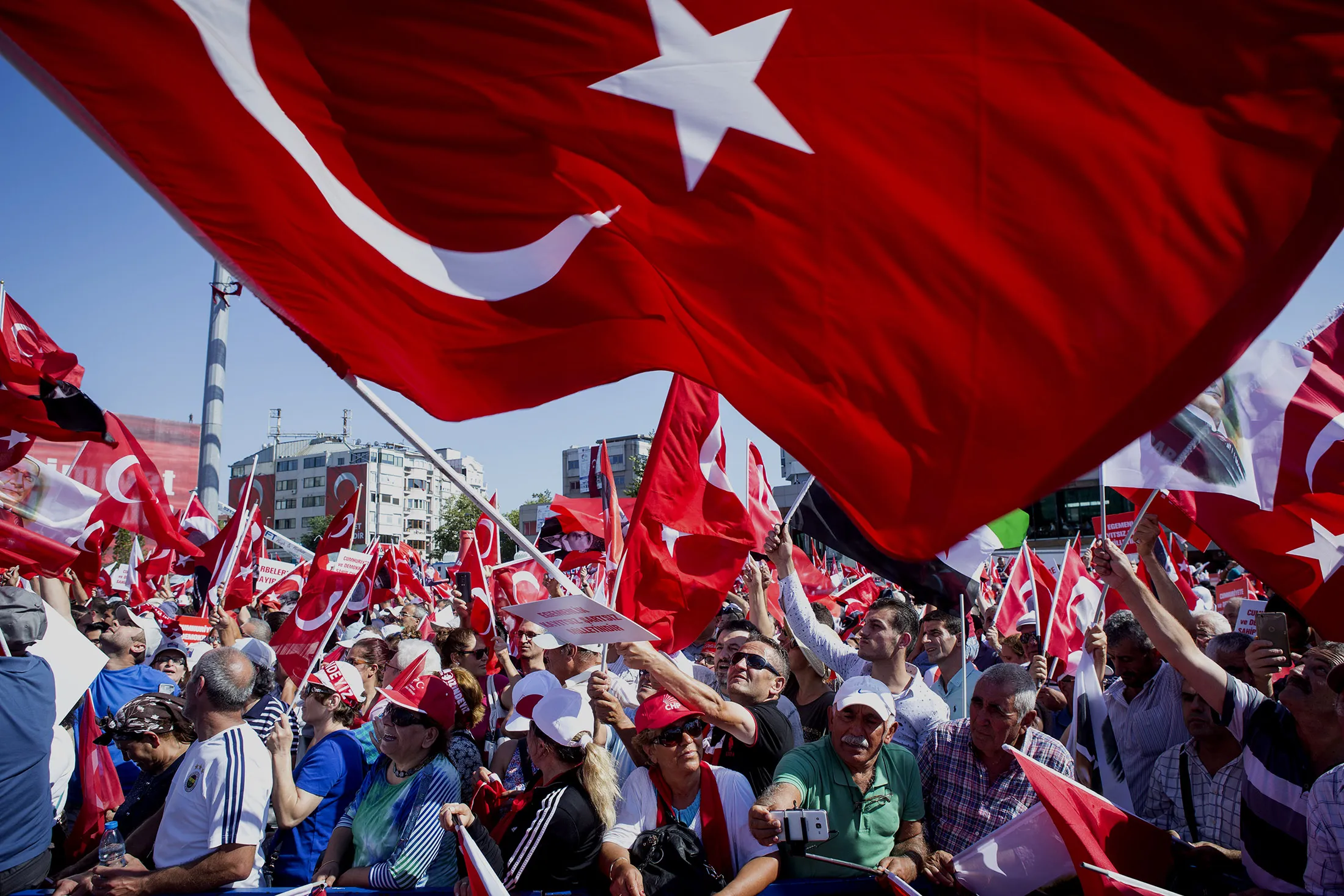 Political supporters wave Turkish national flags during a pro democracy demonstration in Istanbul, Turkey, on Sunday, July 24, 2016. Turkey's government is setting up an inner cabinet to oversee the implementation of the state of emergency it declared after the botched coup, ramping up the effort to purge the influence of its accused mastermind.
