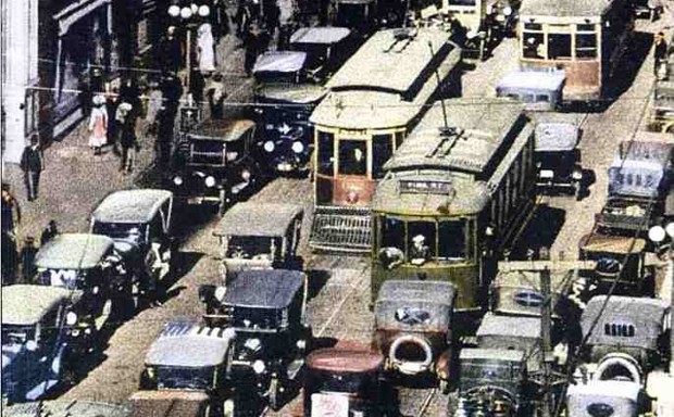 Vintage Kansas City streetcars negotiate heavy traffic. 