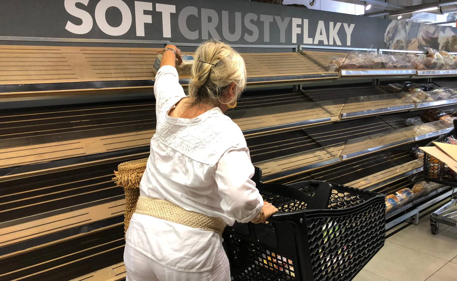 A customer picks up an item from the bread shelves at a supermarket in Johannesburg on March 16.