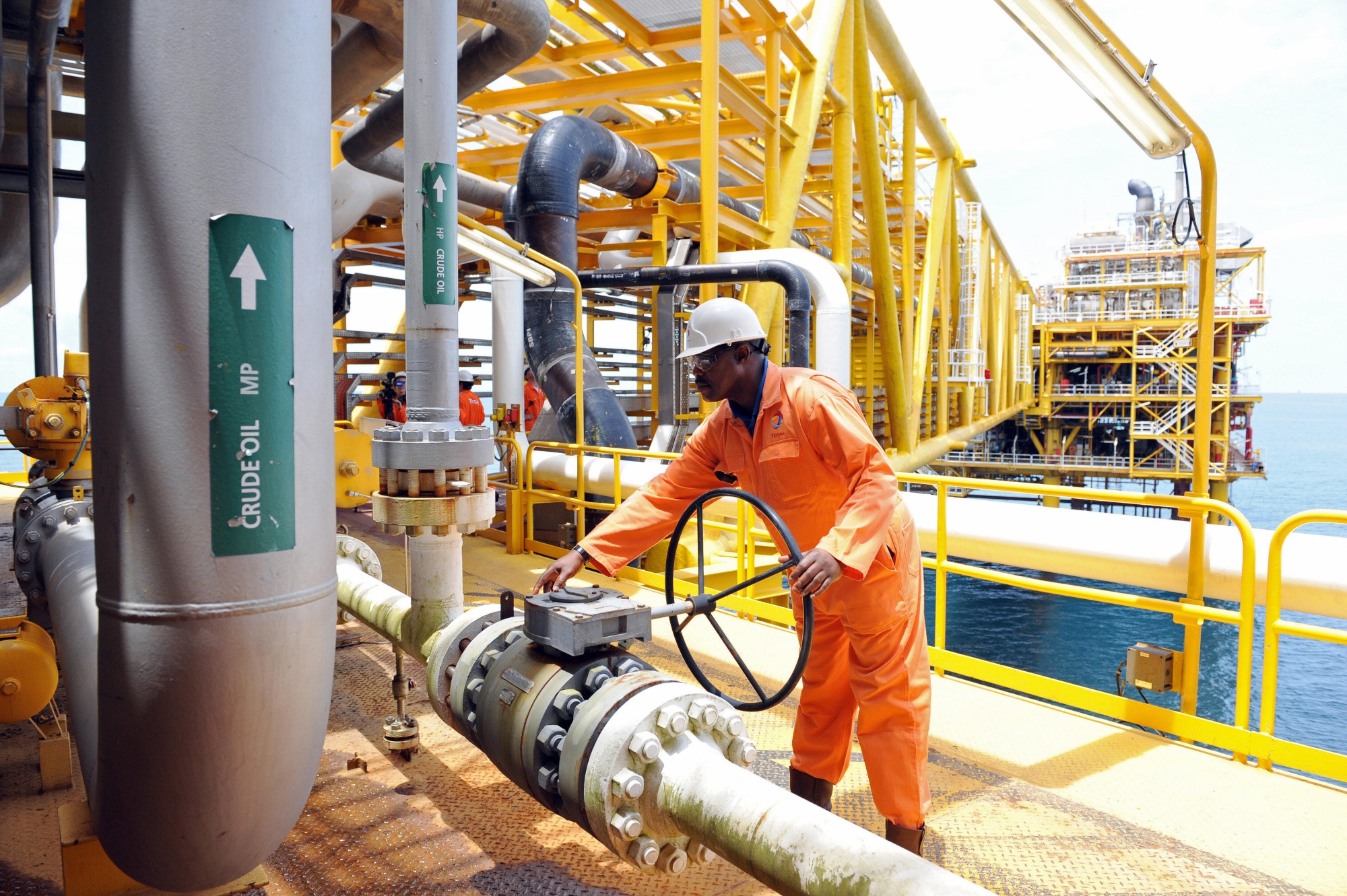 A worker inspect facilities on an upstream oil drilling platform at the Total oil platform at Amenem, 35 kilometers away from Port Harcourt in the Niger Delta. Amenem is the hub of Total oil production with two oil well producing over 100,000 barrels of crude daily. AFP PHOTO / PIUS UTOMI EKPEI (Photo credit should read PIUS UTOMI EKPEI/AFP via Getty Images)
