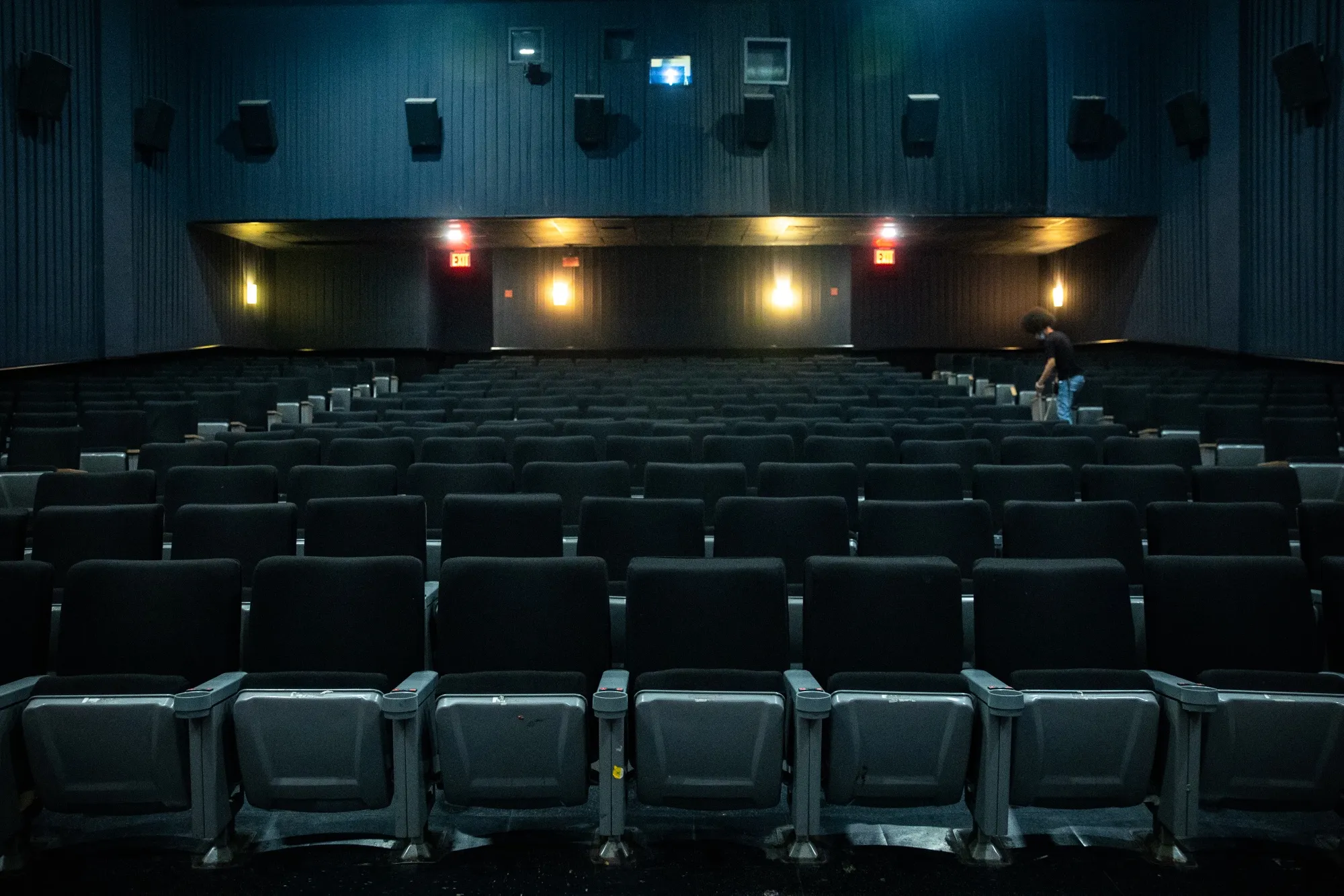 An employee cleans an auditorium at the AMC Lincoln Square 13 movie theater in New York.