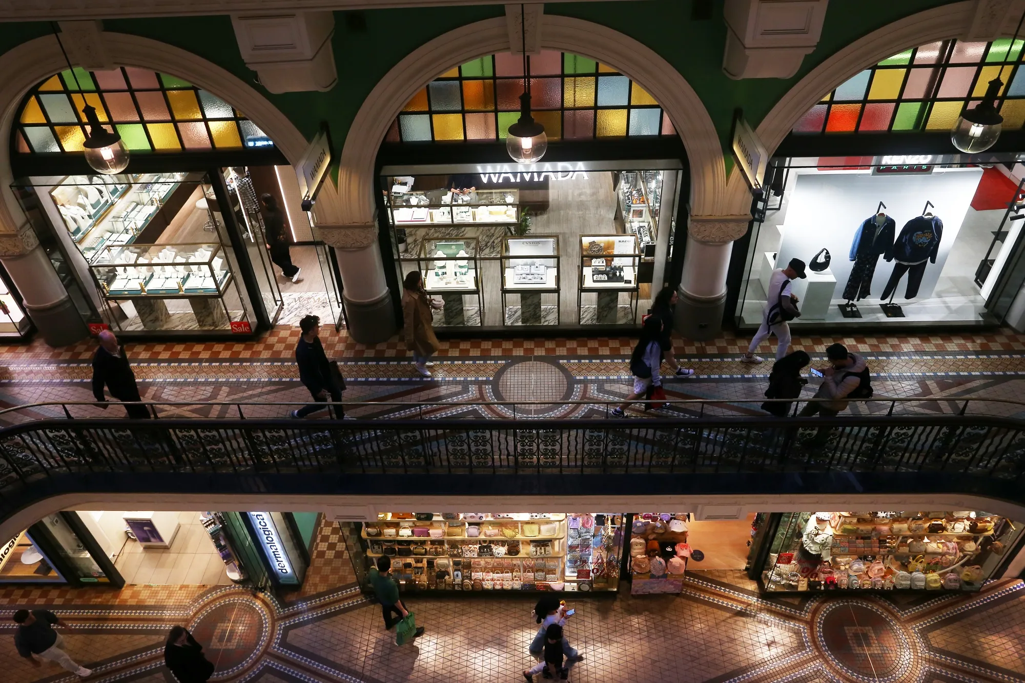 Pedestrians pass shops in the Queen Victoria Building in Sydney, Australia.