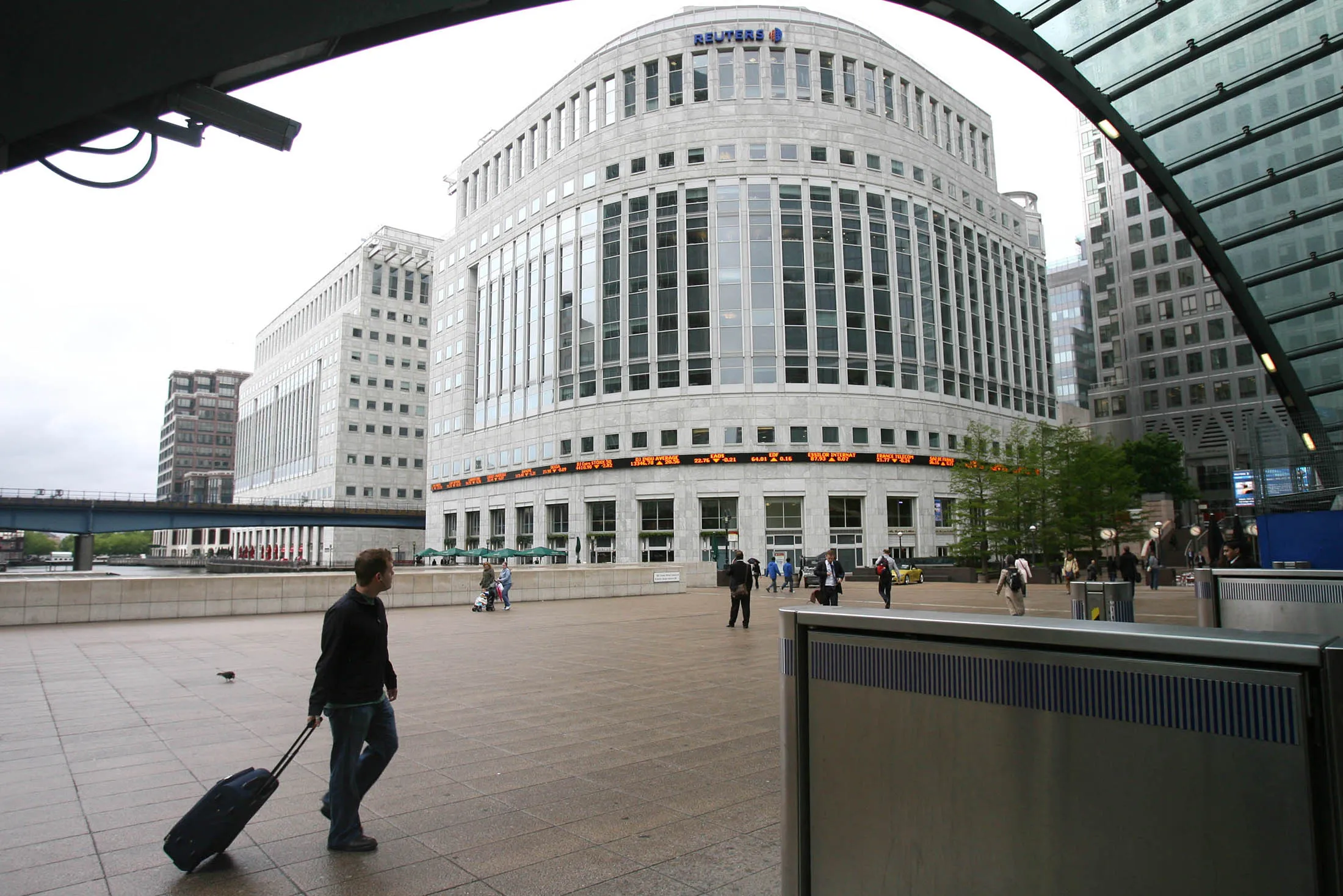 Pedestrians walk past the Reuters headquarters in London's Canary Wharf.
