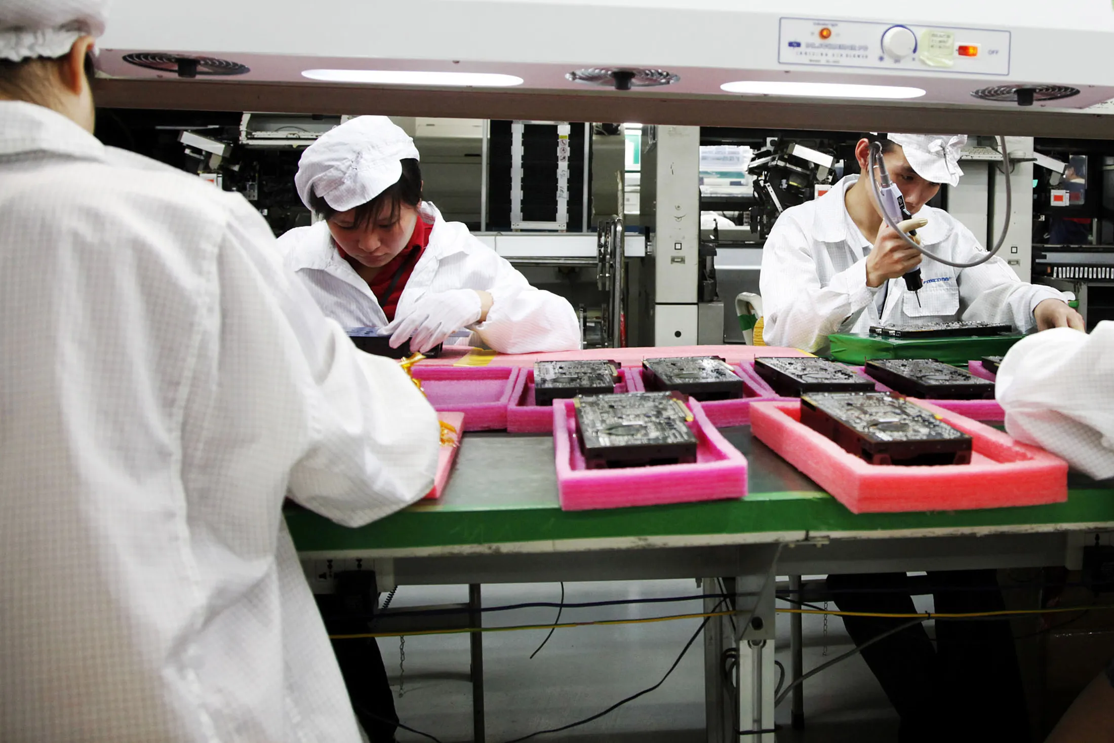 Foxconn employees operate on the assembly line at the Foxconn factory in Longhua, Shenzhen, China, on May 26, 2010.

