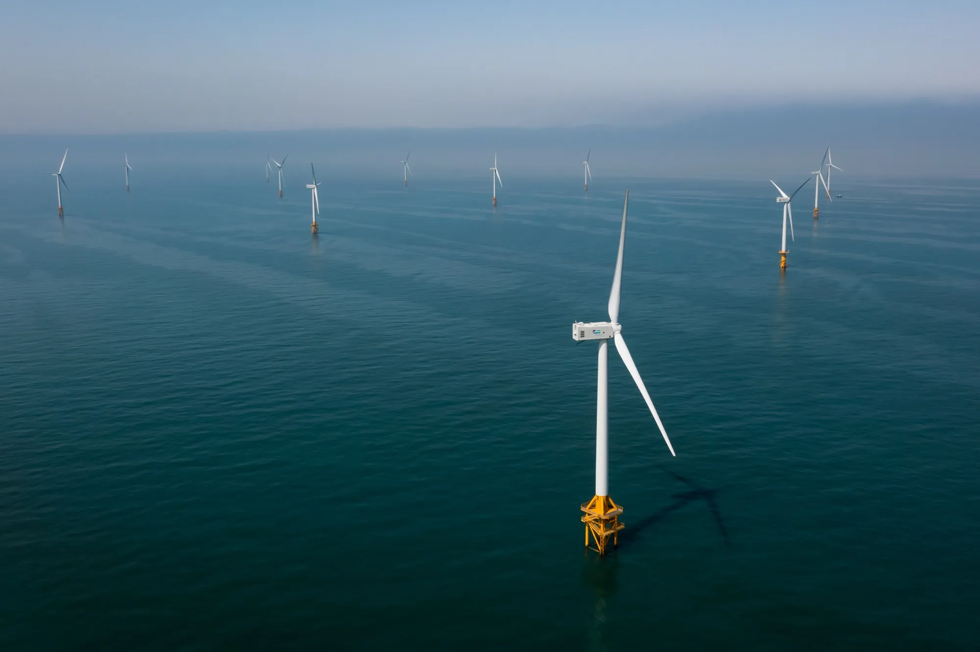 Wind turbines operate at an offshore wind farm in the pacific ocean.&nbsp;