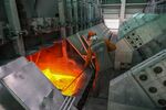 A worker removes slag from an electrolysis bath at an aluminium smelter, operated by United Co. Rusal, in Sayanogorsk, Russia.
