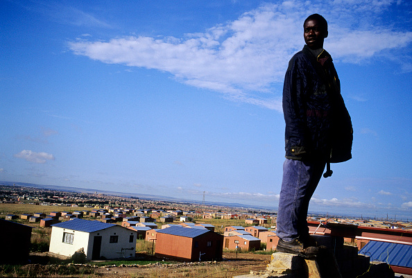 A worker stands on the roof of a RDP (“Rapid Development Program”) house, also known as a “Mandela house,” in Soweto, in February 2004.