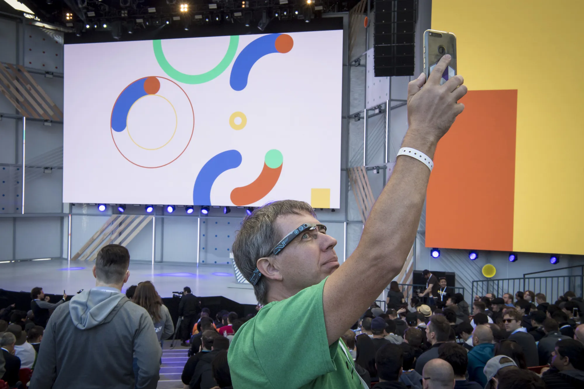 An attendee wearing Google Glass glasses takes a photograph with a smartphone before the Google I/O Developers Conference in Mountain View, California, on&nbsp;May 8, 2018.