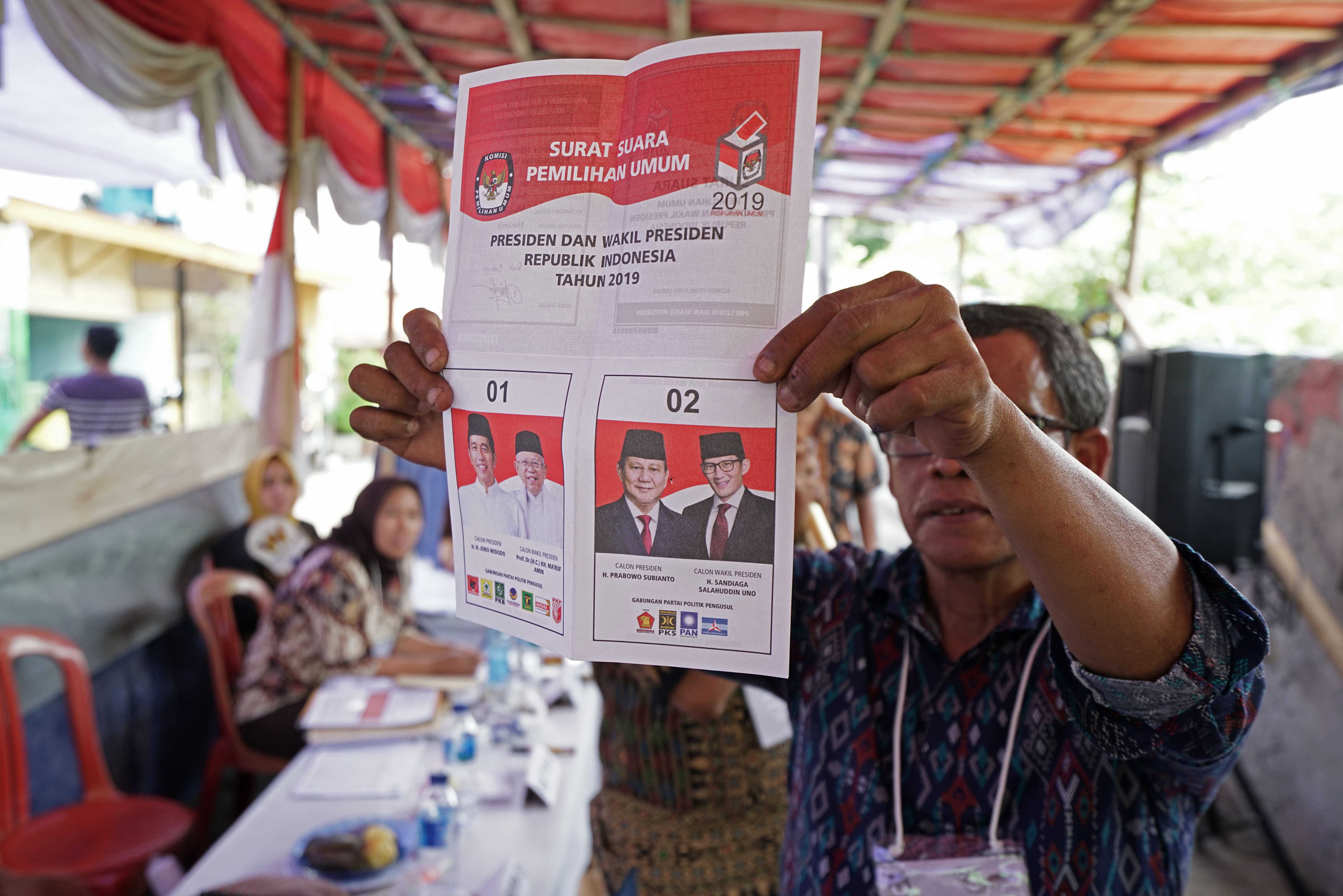 An election official holds a ballot during the counting for the general elections at a polling station in Jakarta, Indonesia, on Wednesday, April 17, 2019. Indonesians have voted in the world’s biggest single-day election, with unofficial tallies putting President Joko Widodo ahead with 55 percent with around 38 percent of votes counted.