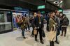 Volunteers exit a carriage onto a platform during a test run of an Elizabeth Line train at Paddington Station