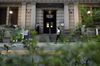 A security guard wearing a protective face mask, left, stands outside the Bank of Japan (BOJ) headquarters in Tokyo, Japan, on Monday, Sept. 14, 2020. The Bank of Japan left its bond-purchase amount unchanged at a regular operation on Monday.