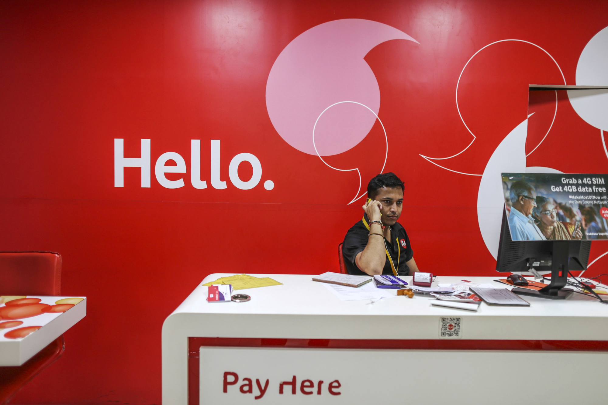 A man speaks on the phone inside a Vodafone India Ltd. store&nbsp;in Mysore.