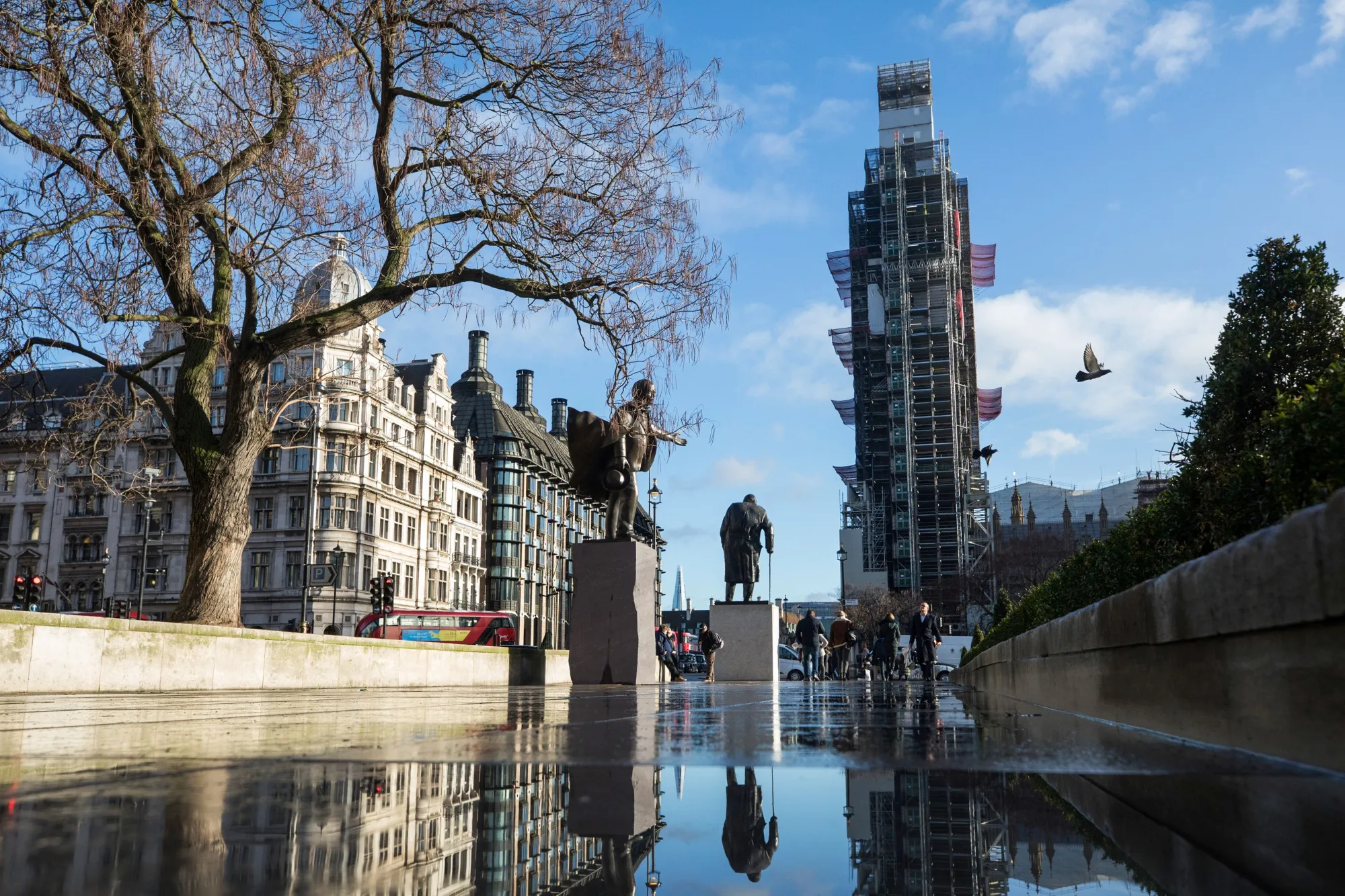 A statue of Winston Churchill stands against a backdrop of the Elizabeth Tower outside the Houses of Parliament in London.