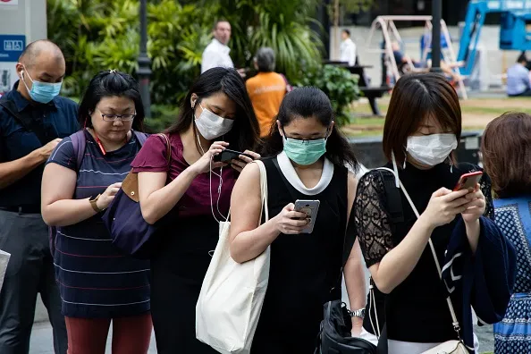 Awaiting temperature checks outside a Singapore office building.