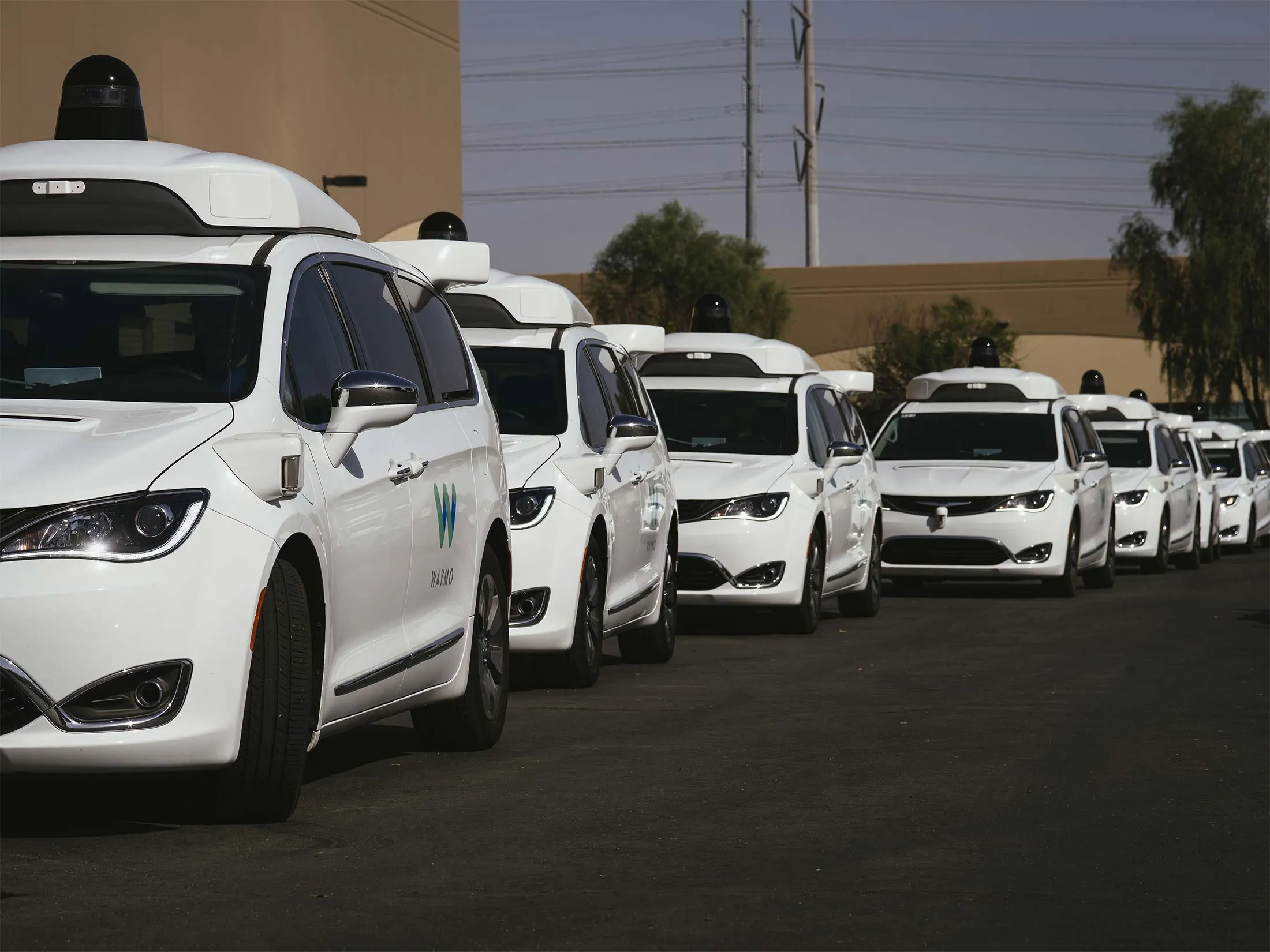Waymo self-driving vehicles line up to re-enter the company's facility after morning test drives in Chandler, Ariz., Oct. 21, 2017.