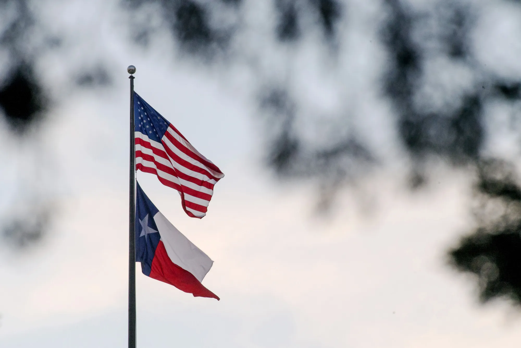 An American flag flies with the Texas state flag&nbsp;in Austin, Texas.&nbsp;