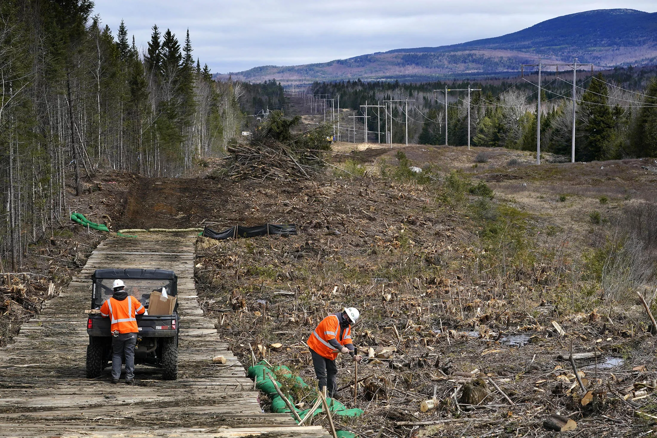 Workers place stakes to mark land for new utility poles on a segment of the New England Clean Energy Connect&nbsp;near Bingham, Maine.