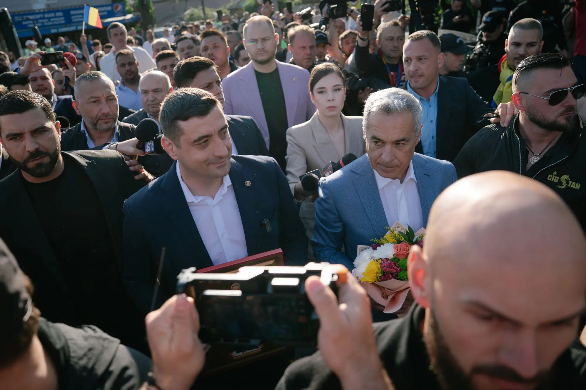 Calin Georgescu, center right, walks next to George Simion, center left, in Mogosoaia, Romania, on May 4.&nbsp;
