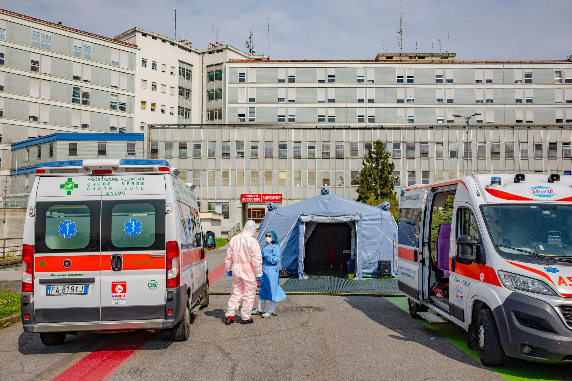 Medical workers stand between ambulances at the pre-triage tent outside a hospital in Cremona, Italy.