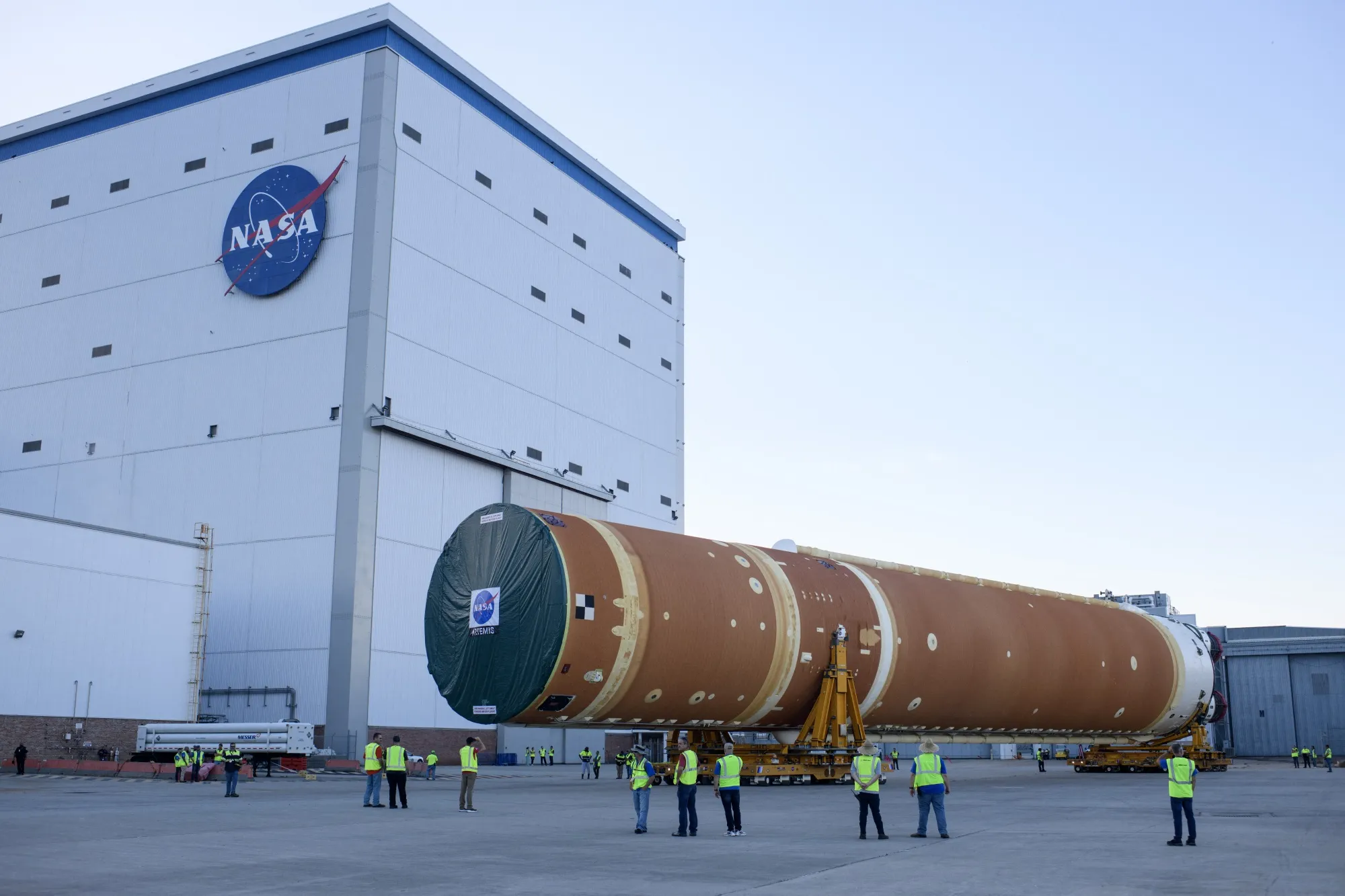 NASA employees watch as the Artemis II rocket core stage is wheeled out at the NASA Michoud Assembly Facility in New Orleans, Louisiana, on July 16.