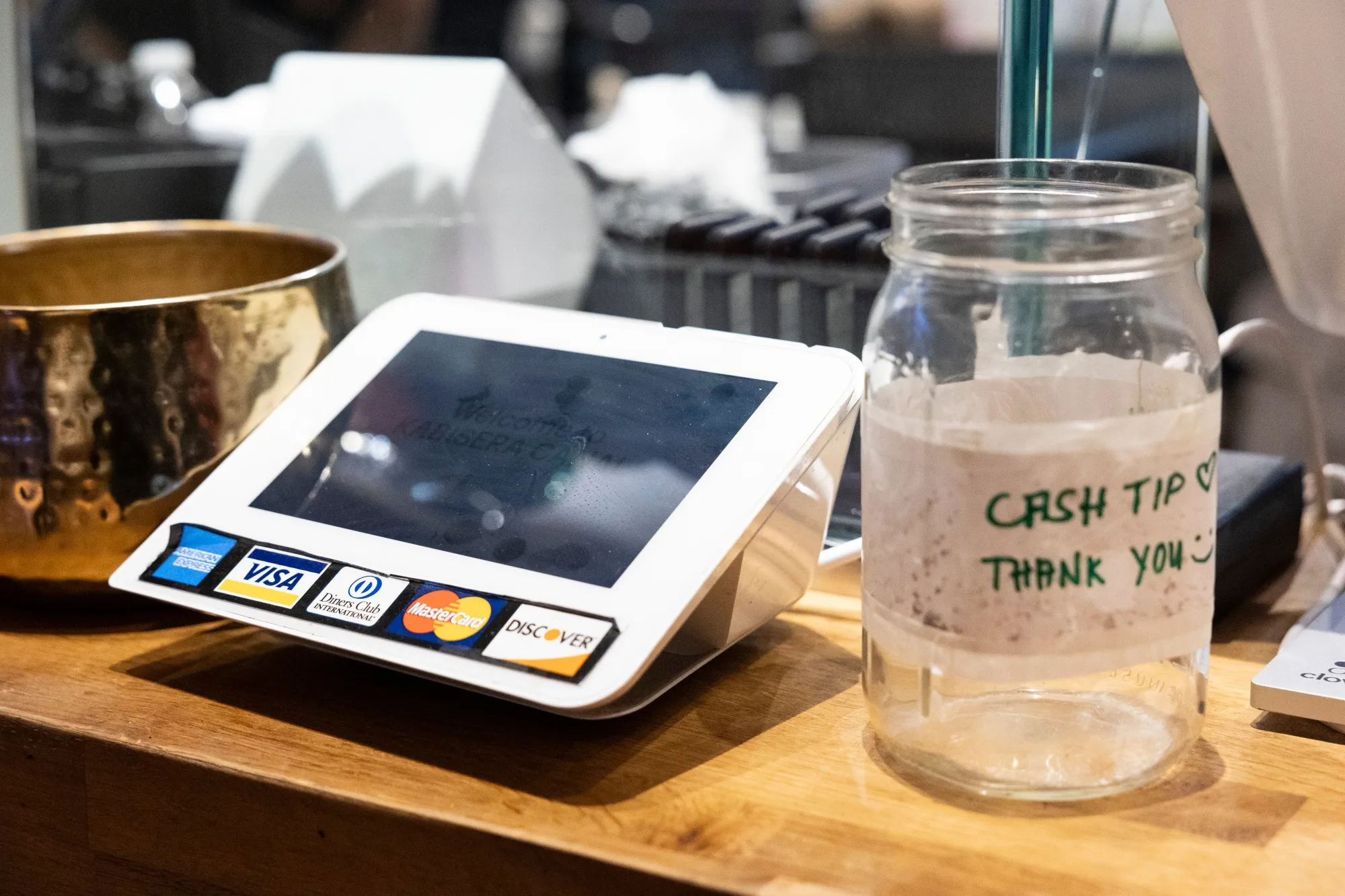 A sticker for American Express, Mastercard, Visa, Discover and credit cards displayed at a business in New York.
