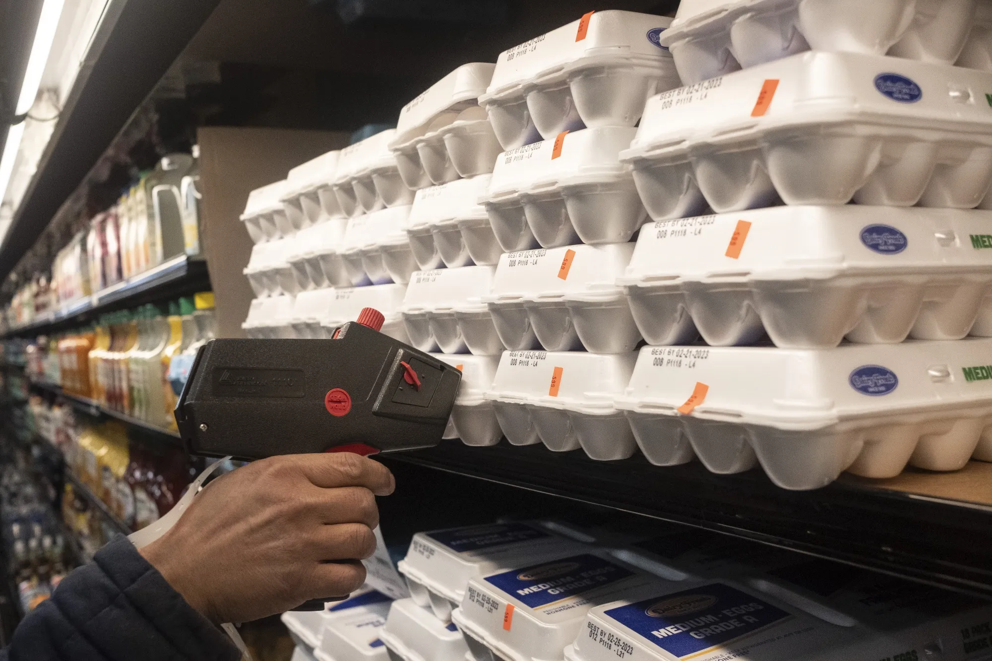 A worker prices eggs on a shelf at a grocery store in Detroit.