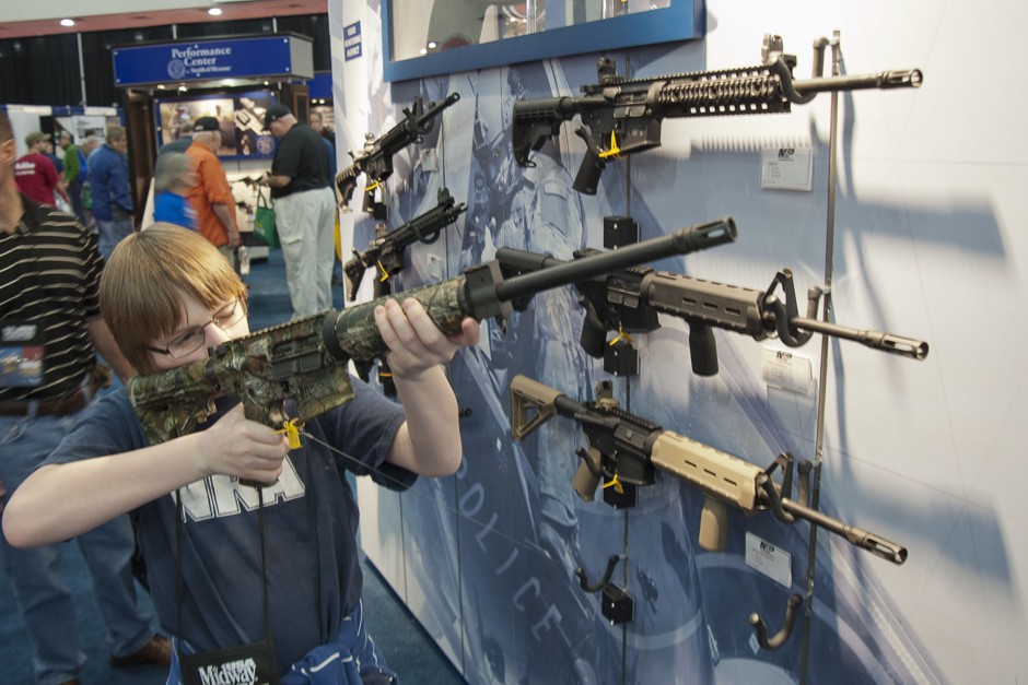 A young boy holds up an assault rifle at an NRA convention in Houston in 2013.