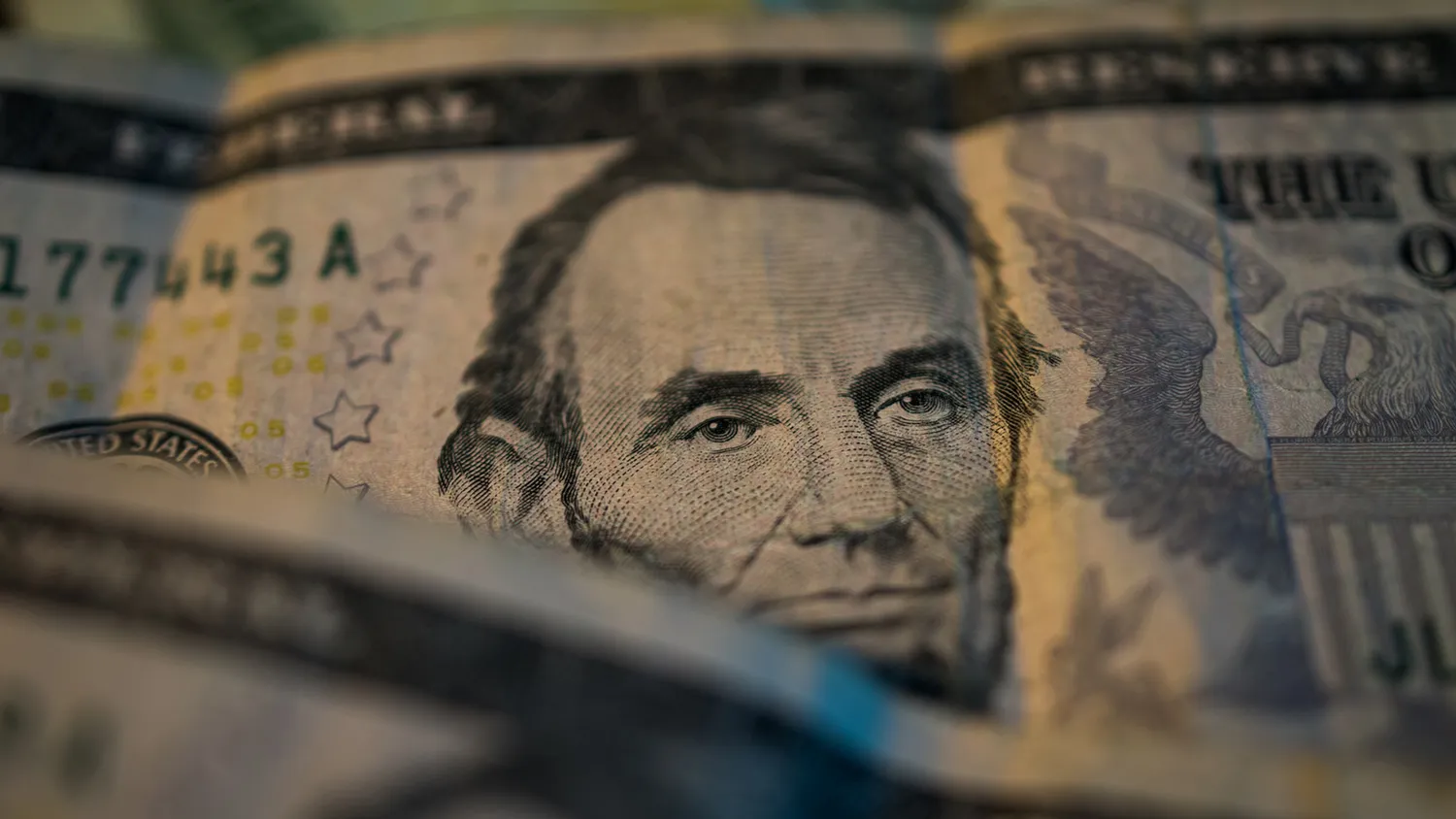 U.S. five dollar bills are seen in this arranged photograph to illustrate the theme of risk in Oradell, New Jersey, U.S., on Thursday, June 18, 2015.
