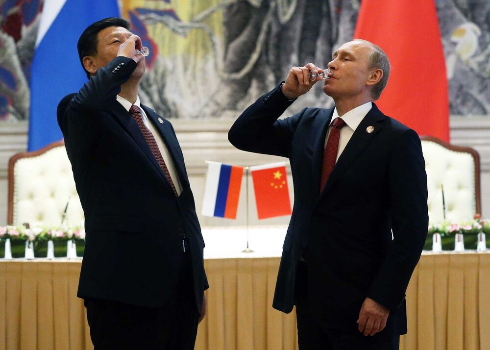 Chinese President Xi Jinping and Russian President Vladimir Putin toast with vodka during a signing ceremony on May 21, 2014, in Shanghai. Russia and China signed a 30-year contract for supply of gas.