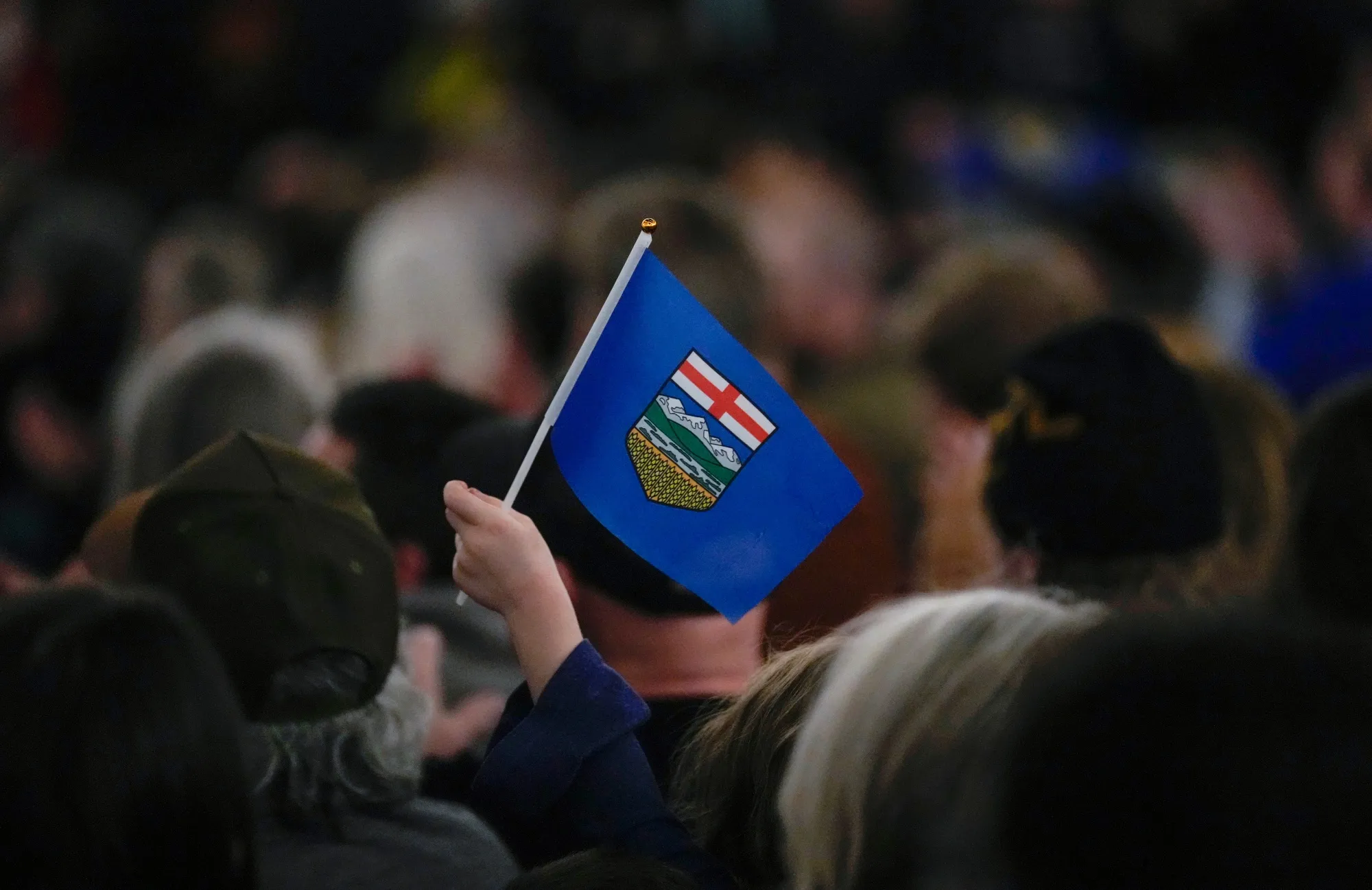 An attendee holds an Alberta flag during the Alberta Independence town hall event in Calgary in January.