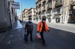Pedestrians walk along a usually busy street in Palermo, Italy,.