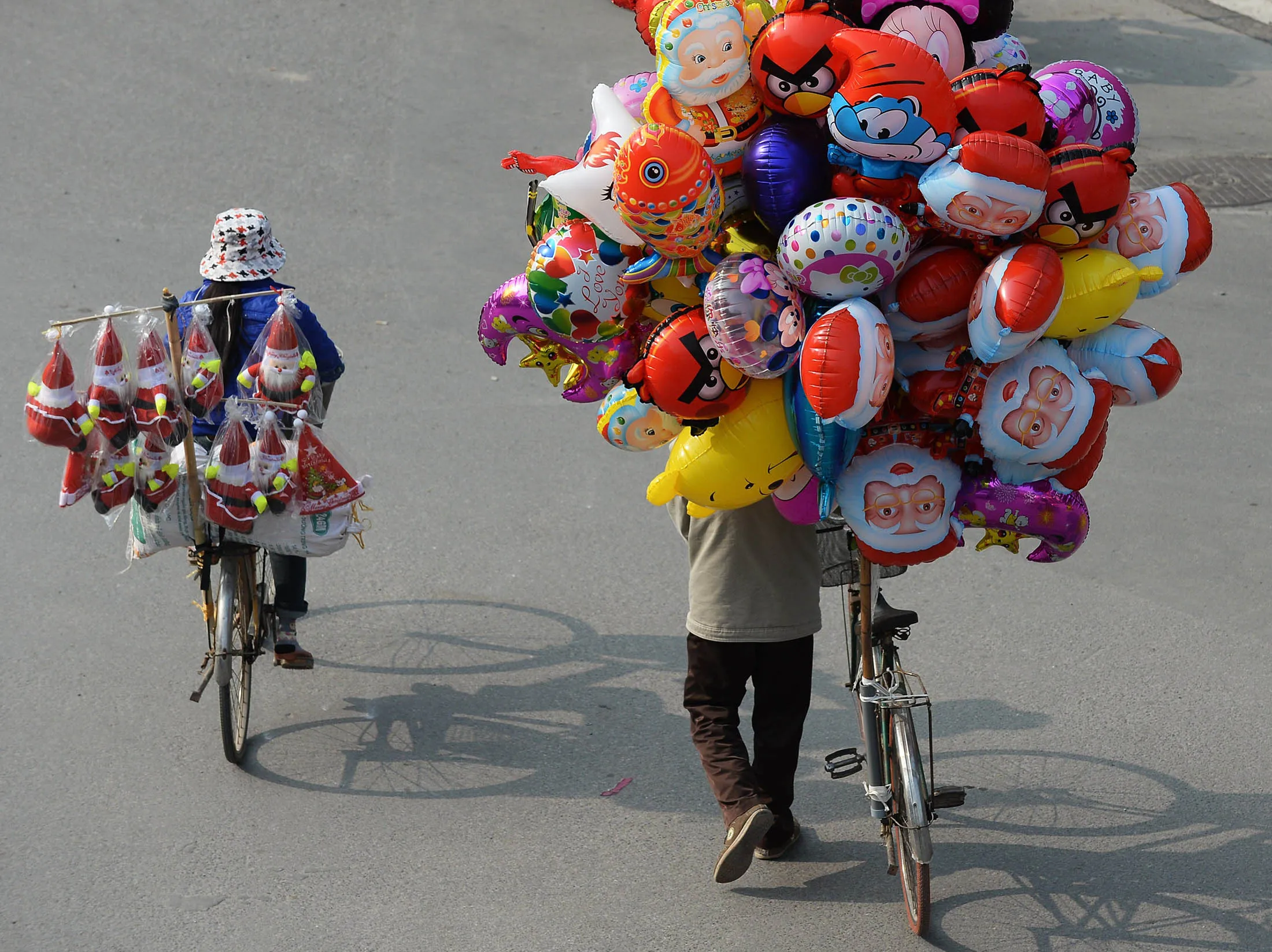 Vendors sell Christmas dolls and balloons on a street in Hanoi on December 24, 2013. Vietnam's economy grew 5.42 percent in 2013, picking up speed slightly after its worst performance in more than a decade the previous year, according to an official estimate released on December 23. AFP PHOTO/HOANG DINH NAM (Photo credit should read HOANG DINH NAM/AFP/Getty Images)
