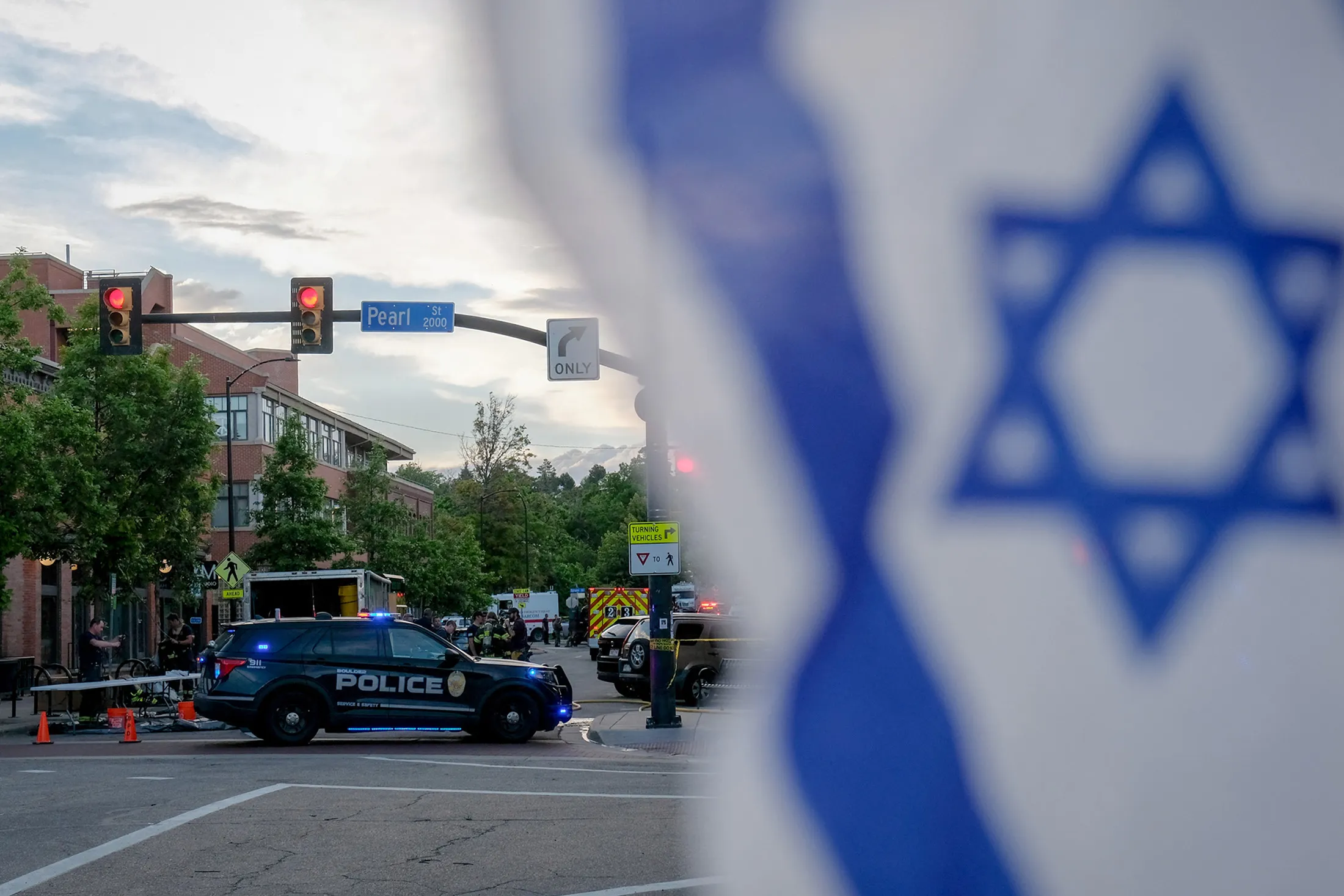 An Israeli flag fixed to a street sign as police stand by off Pearl Street on the scene of an attack in Boulder, Colorado, on June 1.
