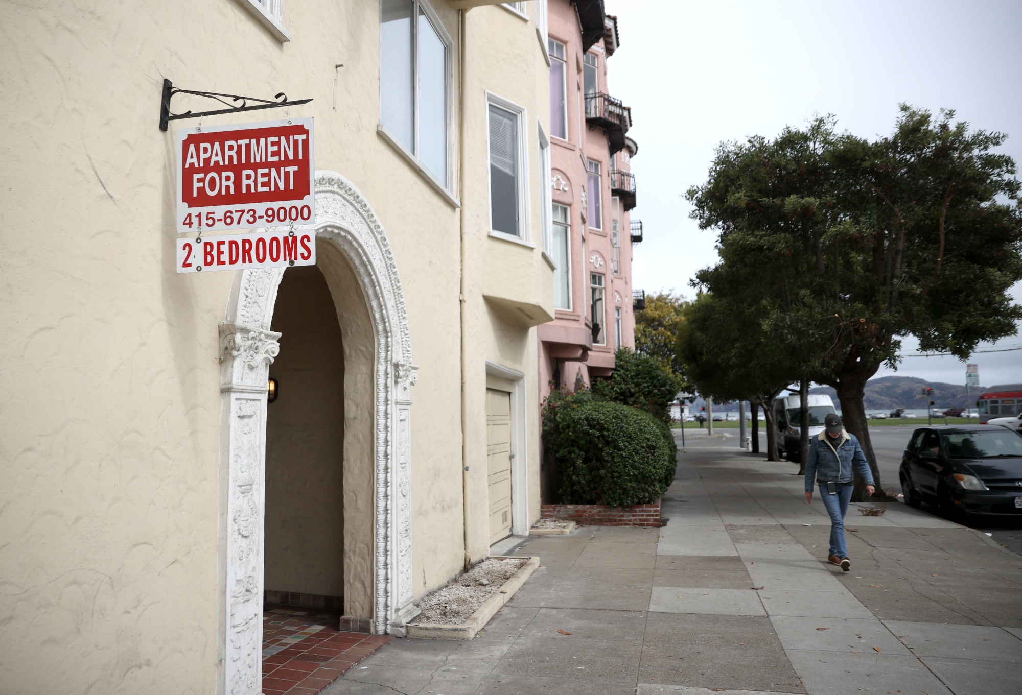 A pedestrian walks by a &quot;for rent&quot; sign in front of an apartment building&nbsp;in San Francisco, where prices have surged back to pre-pandemic levels.&nbsp;