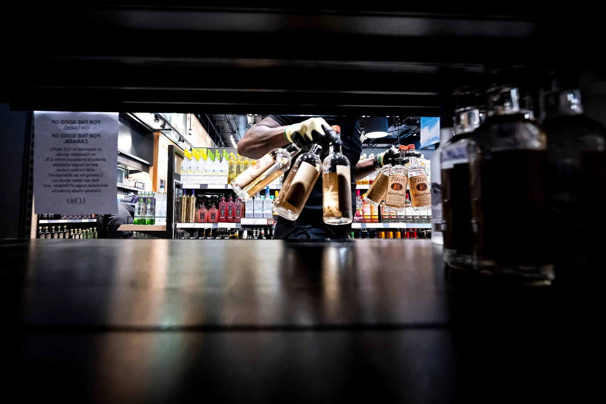 A worker removes bottles of American-made vodka from a shelf at the Liquor Control Board of Ontario store in Toronto in March 2025.