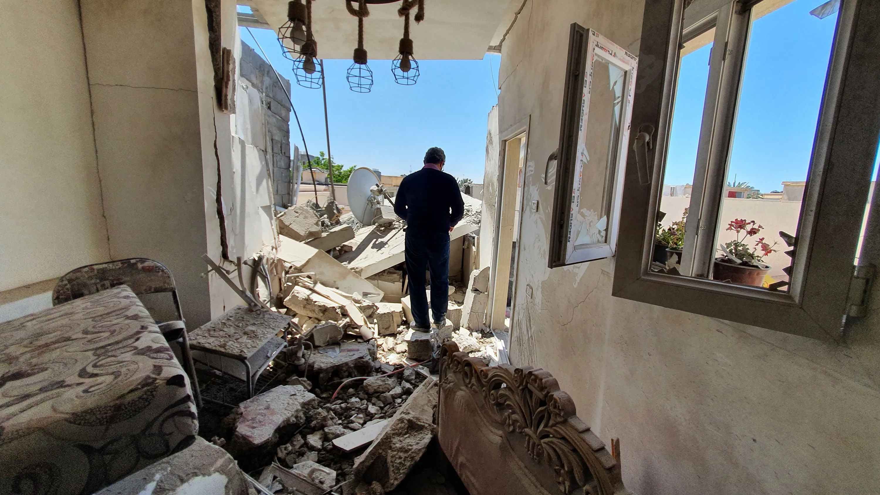 A resident walks in the rubble of a damaged house in Tripoli on May 31.&nbsp;