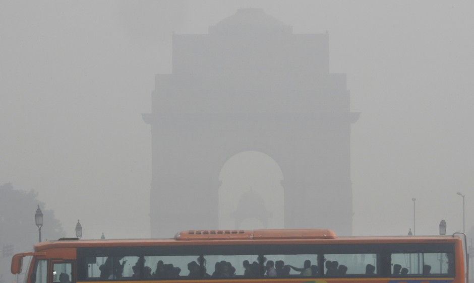 A bus moves past a smog-enshrouded India Gate in Central Delhi.
