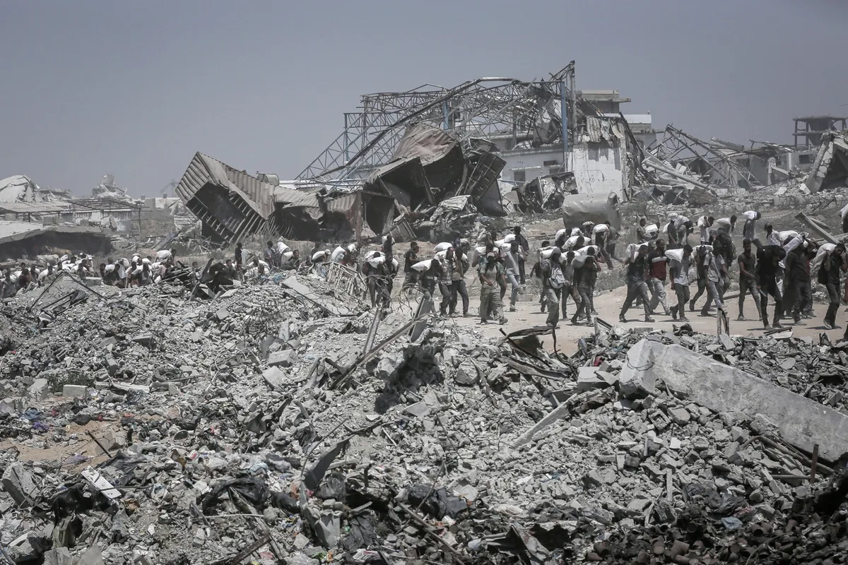 Palestinians carry food aid that entered Gaza from Israel in Beit Lahia, northern Gaza, on July 27.