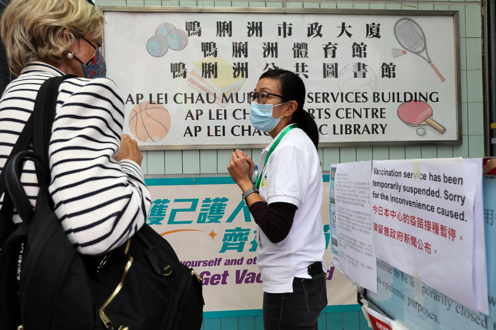 A staff member assists a person at a closed vaccination center in Hong Kong on March 24.
