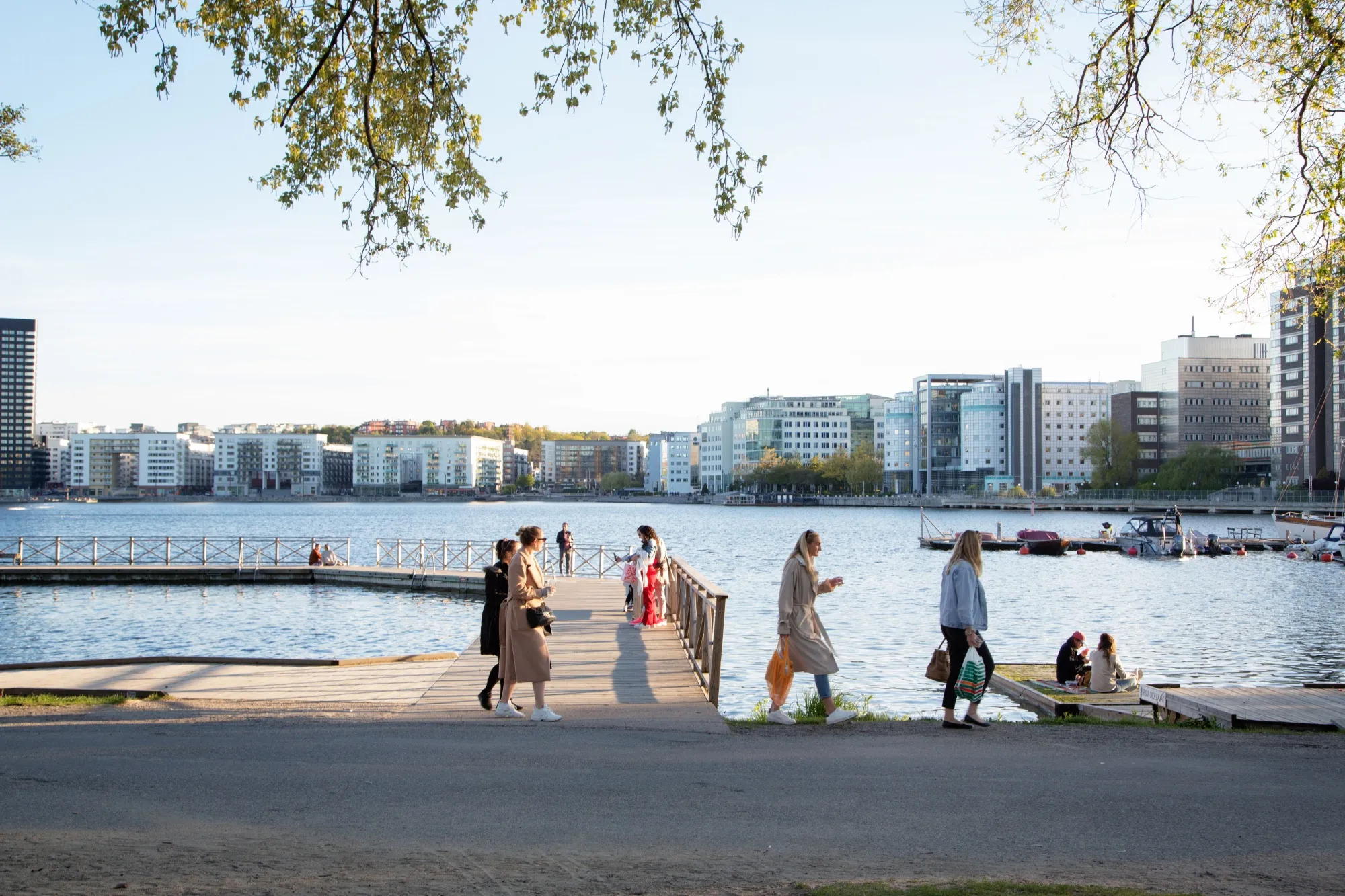 A group of people socialize on a jetty on the water's edge at Tantolunden in Stockholm.&nbsp;Home prices in Sweden were down 11% year-over-year in September.